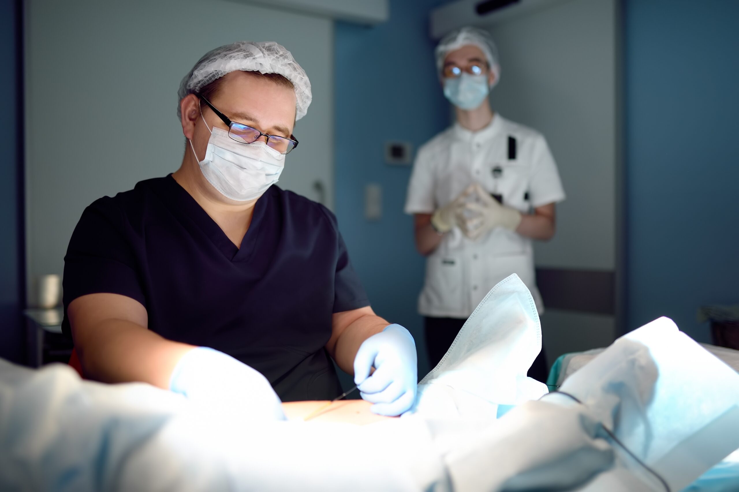 Professional vascular surgeon and assistant in the operating room of the clinic during vein surgery