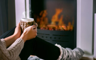 woman sitting in front of fire place during the winter taking care of her veins