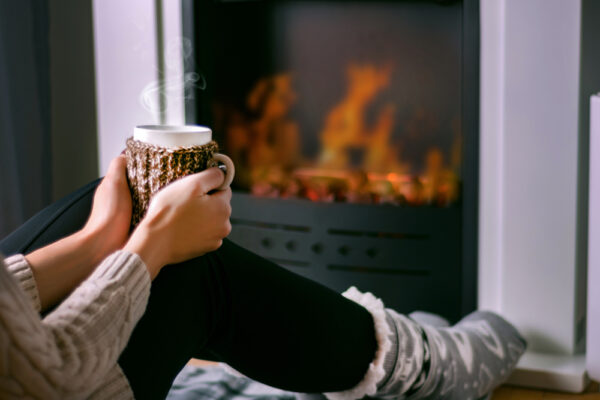 woman sitting in front of fire place during the winter taking care of her veins