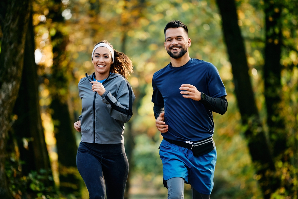 couple running together in the woods to stay healthy and promote good circulation