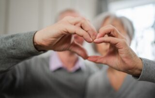 older couple making heart shape with their hands to love their veins